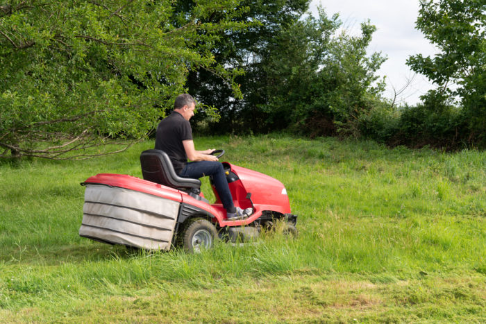 pushing lawn mower vs riding lawn mower